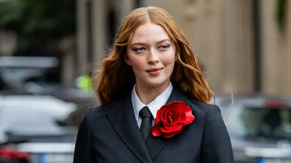 A woman in a red, floral brooch 