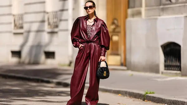 A woman in cherry red pants and jacket outside