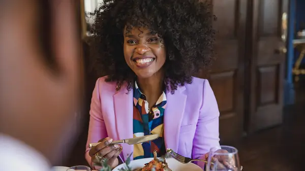 Smiling woman eating in restaurant