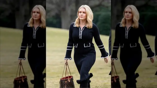 Karoline Leavitt walking outside holding a brown LV bag and wearing a black dress
