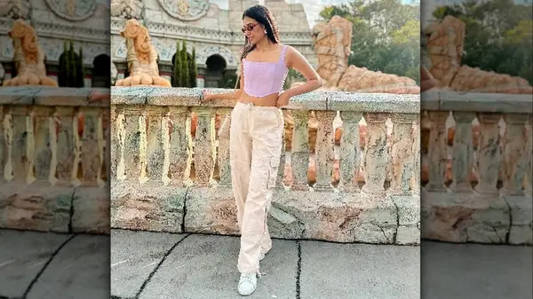 Woman posing by railing in cargo pants and a corset top