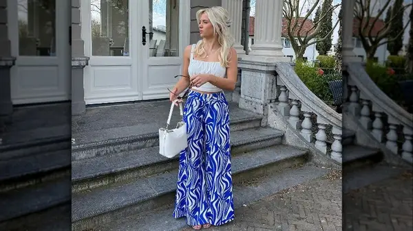 Woman posing in front of steps in printed palazzo pants