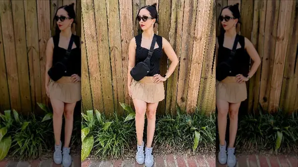 Woman posing outside with sunglasses and belt bag