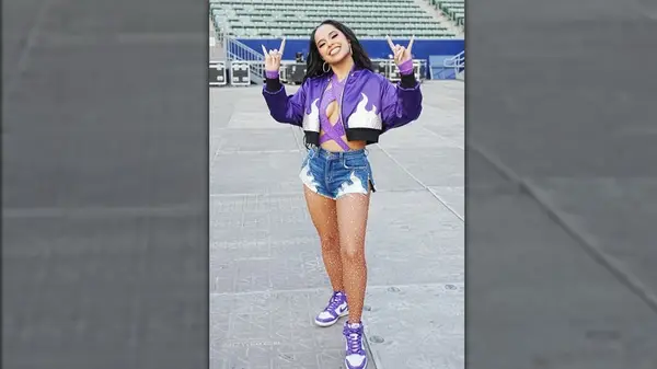 Singer with jean shorts and Nike sneakers