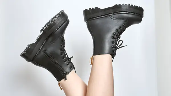 Feet up in the air wearing lug-soled black combat boots