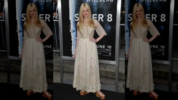 Elle Fanning posing in a cream dress at the premiere of 