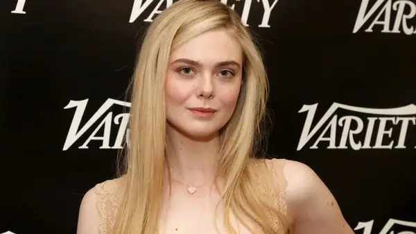 Elle Fanning giving a small smile while looking into the camera