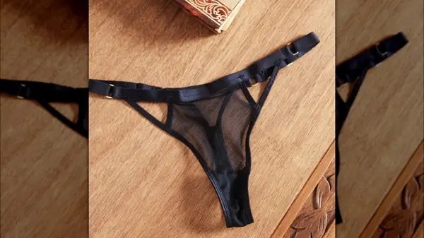 A pair of black thongs on a wooden table