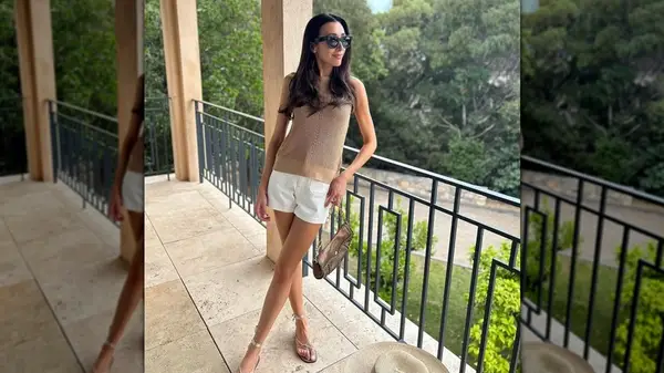 A woman wearing white denim shorts with metallic sandals