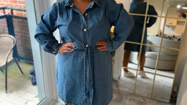 A woman in a mid-wash denim dress