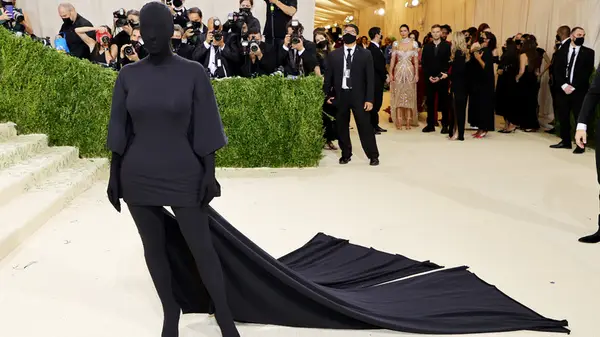 Kim Kardashian in a black t-shirt dress with her face covered