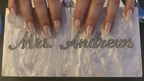 woman holding a purse with the words Mrs. Andrews engraved