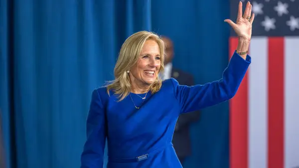 First Lady Jill Biden smiling and waving on stage