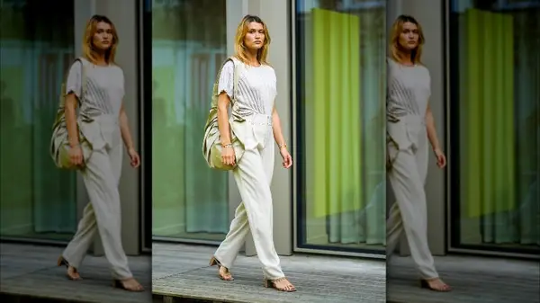 Woman in white trousers walking on sidewalk 