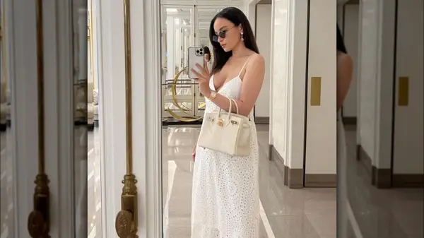 Woman wearing a white dress and cream bag