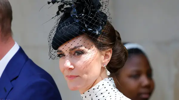 Kate Middleton in a polkadot dress with a black fascinator at an event