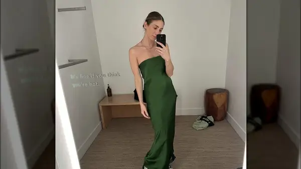 Woman wearing dress in fitting room