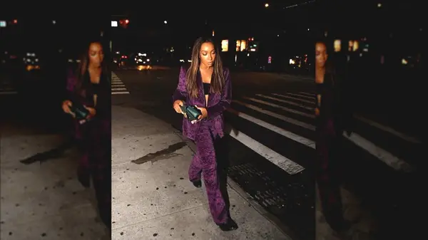 Woman poses on street wearing velvet outfit