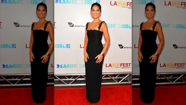 Olivia Munn posing in a black gown with lace detailing in 2012