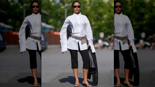 A woman in Copenhagen wearing black capris with a white blouse