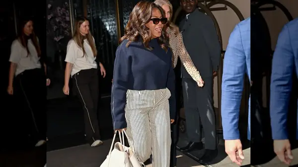 Oprah Winfrey in a blue sweater and striped pants