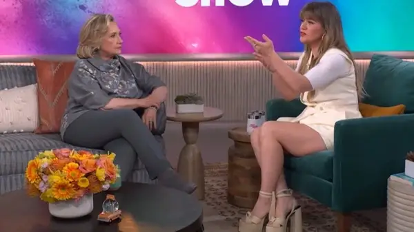 Kelly Clarkson wearing an all-white outfit with chunky, platform heels