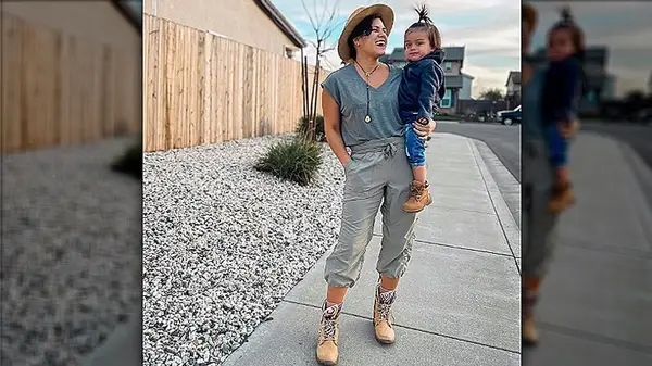 Model in capris holding child
