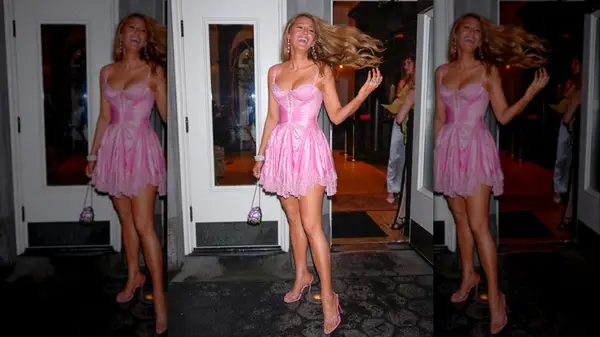 Blake Lively tossing her hair in a pink minidress