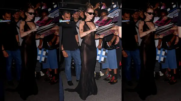 Miley Cyrus signing autographs in a sheer, floor-length black dress