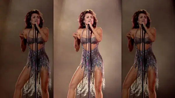 Miley Cyrus performing in a silver fringe dress