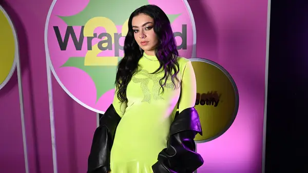 Charli XCX wearing a bright green dress at Spotify Wrapped event