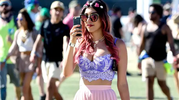 A festival attendee at Coachella in 2016 wearing a flower crown and sunglasses