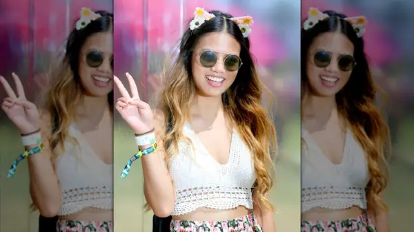 A Coachella guest wearing an animal ear headband and giving the peace sign