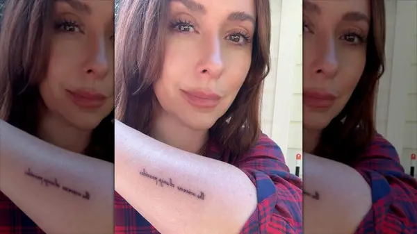 Jennifer Love Hewitt with red hair showing her tattoo