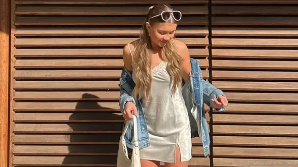 Woman wearing denim jacket and slip dress