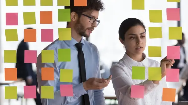 Colleagues reviewing notes on board