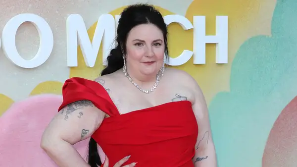 Lena Dunham posing in a red gown