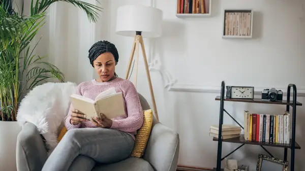 Woman sitting in a chair reading a book