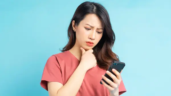 Woman looking at phone confused
