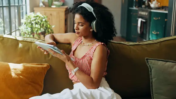 Woman using iPad wearing headphones