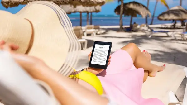 Woman reading a Kindle at the beach