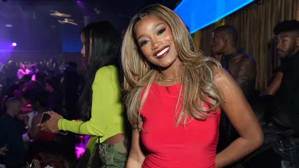Keke Palmer smiling and posing at a crowded Hollywood event in 2024