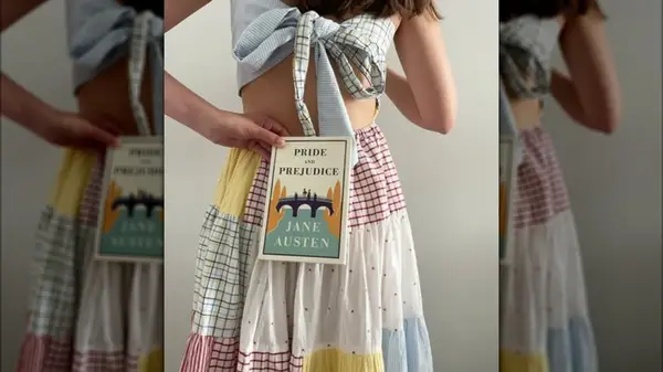 A woman holding a copy of the novel 