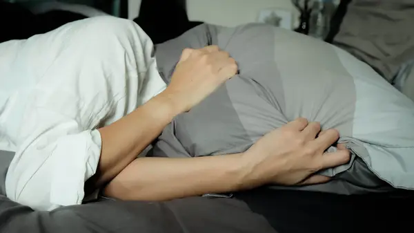 Person holds pillow over face
