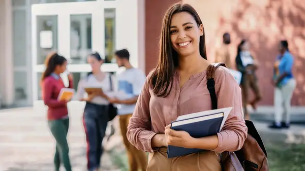 Woman smiling in front of a group of people at school