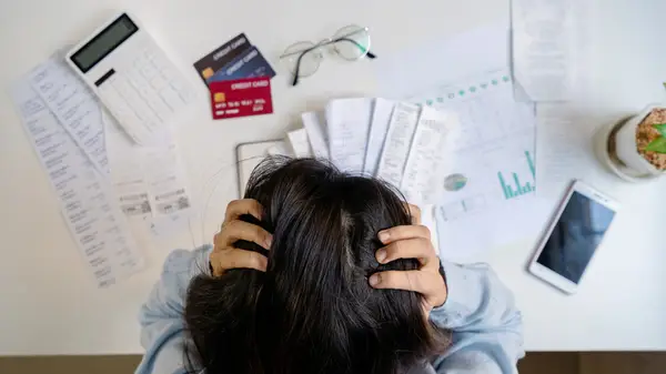 Woman with head in her hands and table of bills