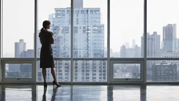 woman looking out of skyscraper