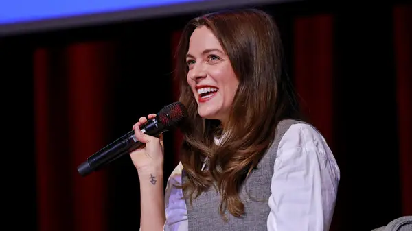 Riley Keough laughing onstage while discussing her book at an event
