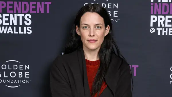 Riley Keough posing with a small smile at a film festival event