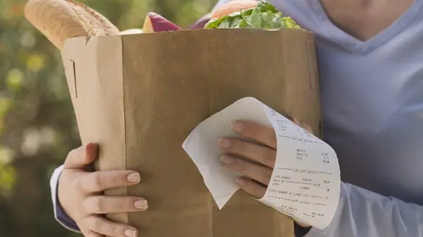 Woman with groceries and receipt